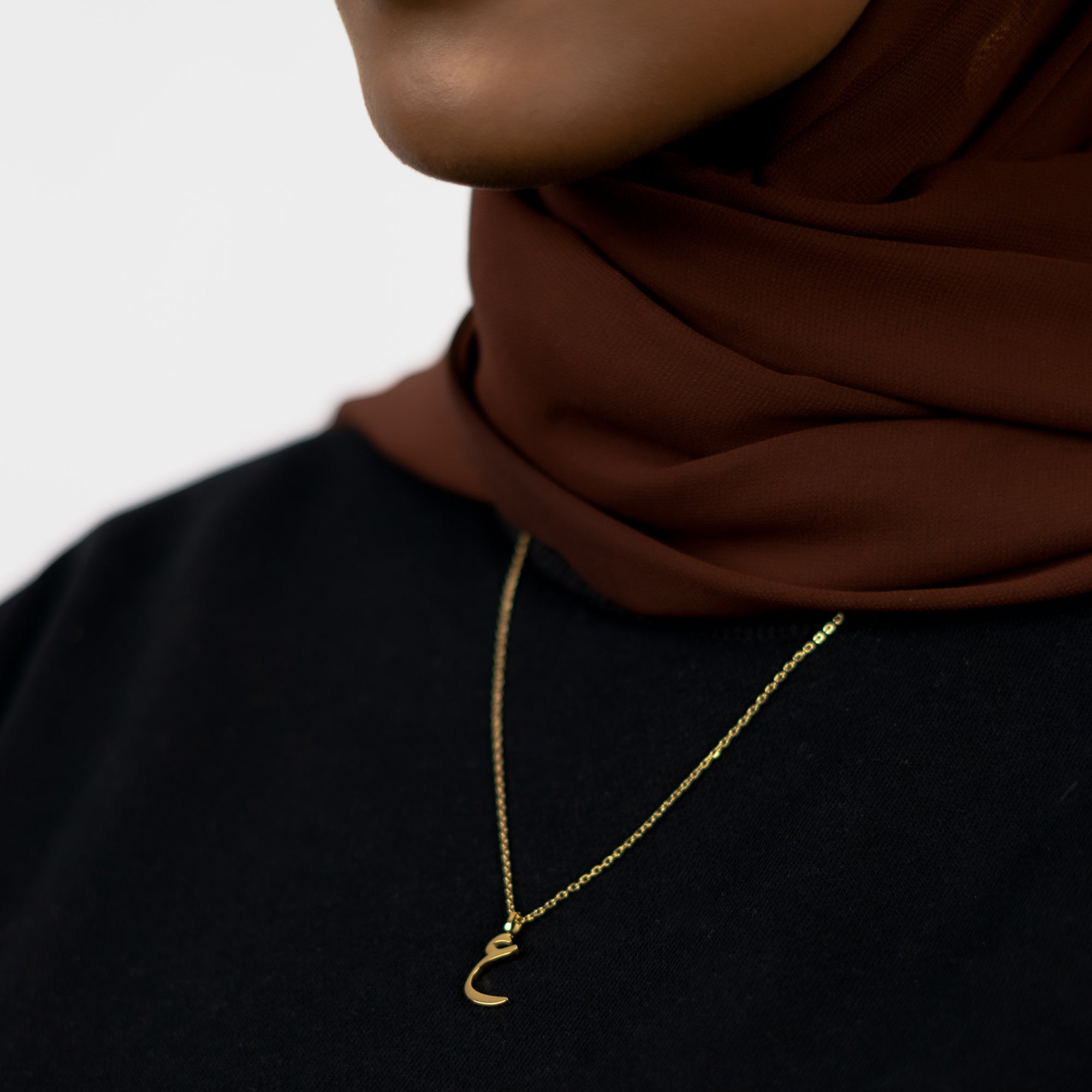 Arabic Letter Necklace Showing The Necklace Worn Around a Woman Wearing a Hijabs Neck
