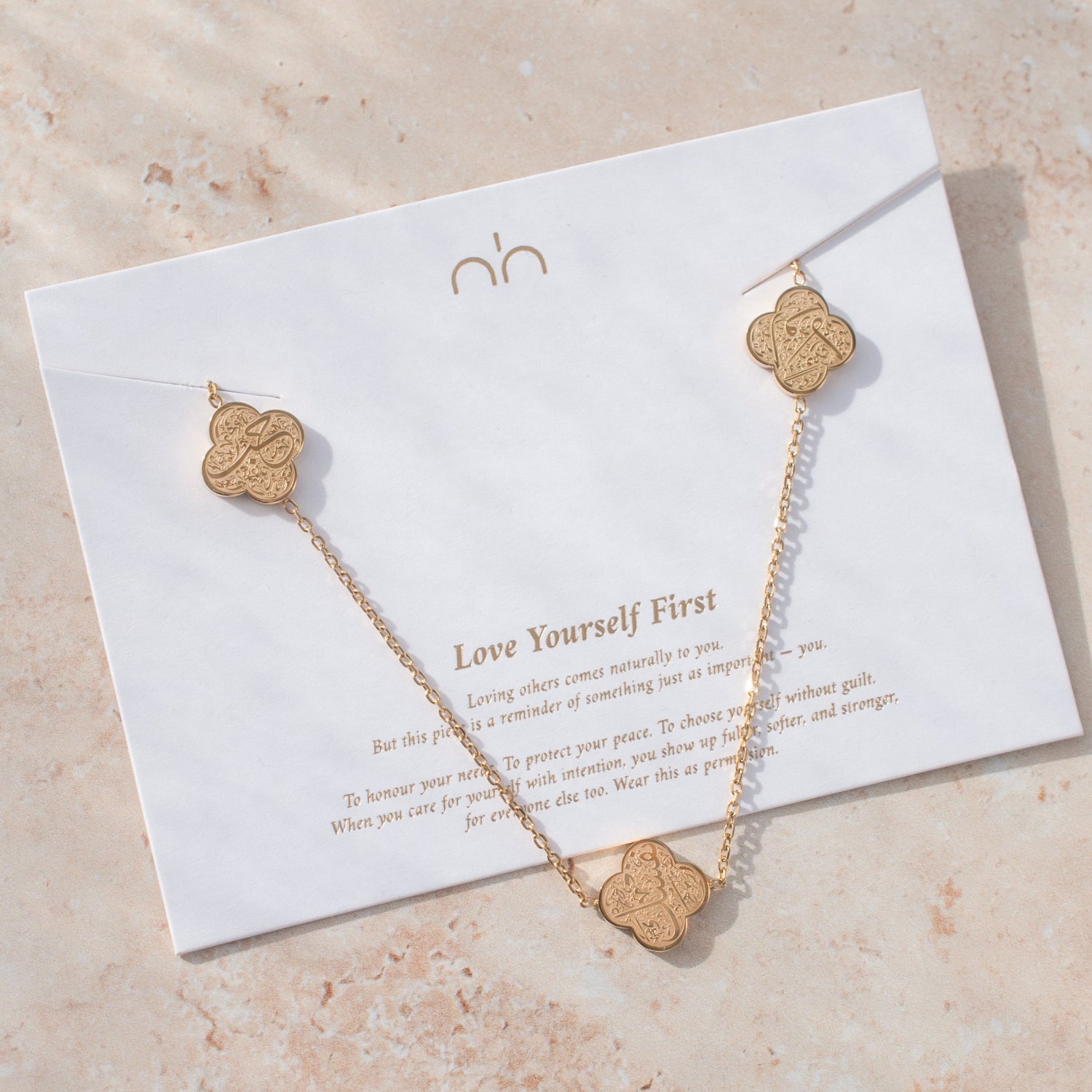 Gold muslim necklace with clover-shaped plove yourself first in arabic pendants on a card with text