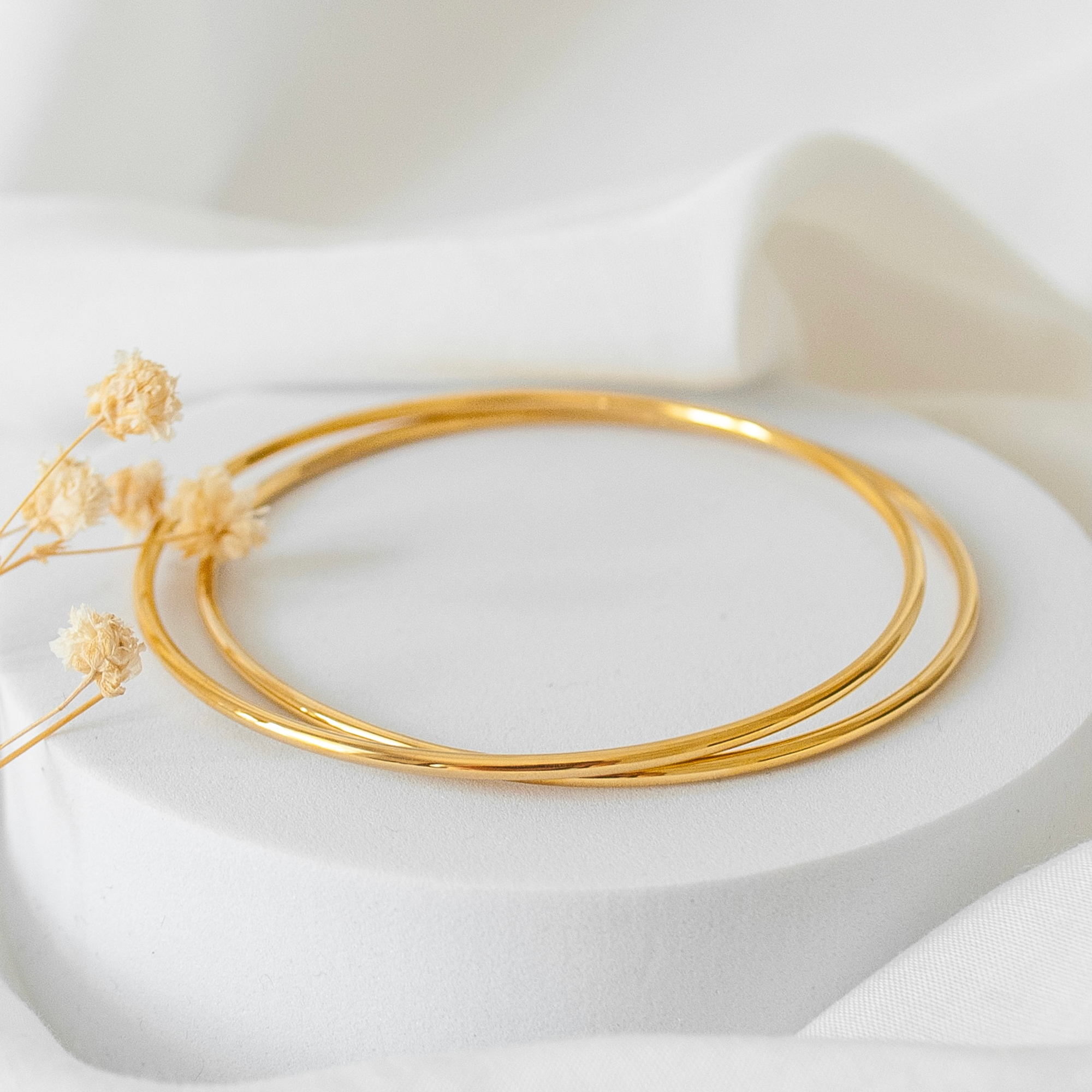 A pair of Arabic gold bracelets layered on a table