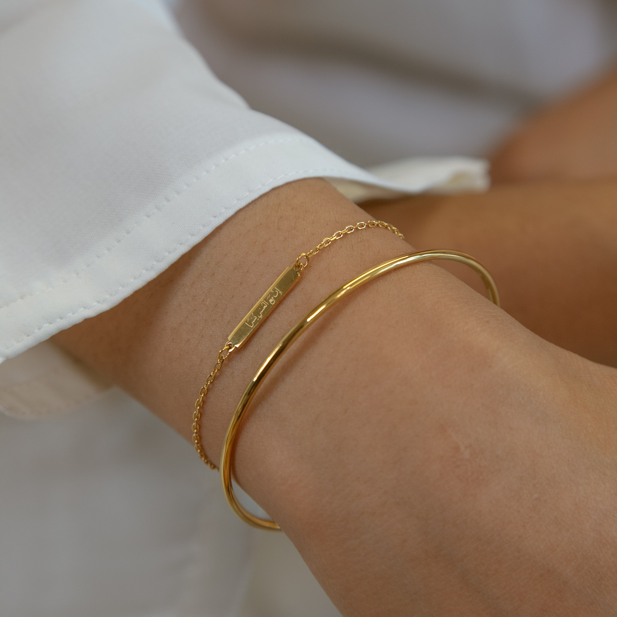 Model wearing stack of gold islamic bracelets