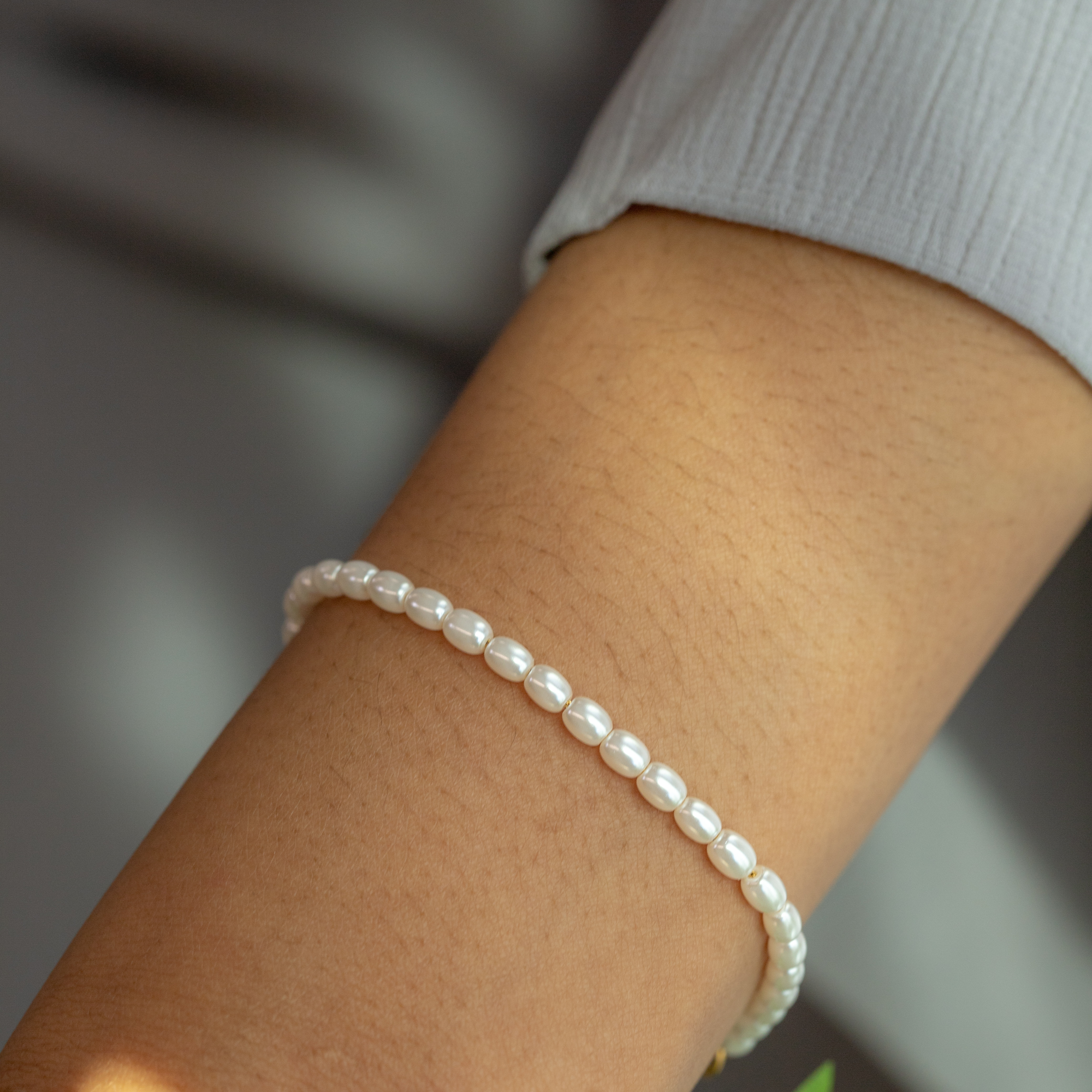Close up image of model wearing pearl islamic bracelet