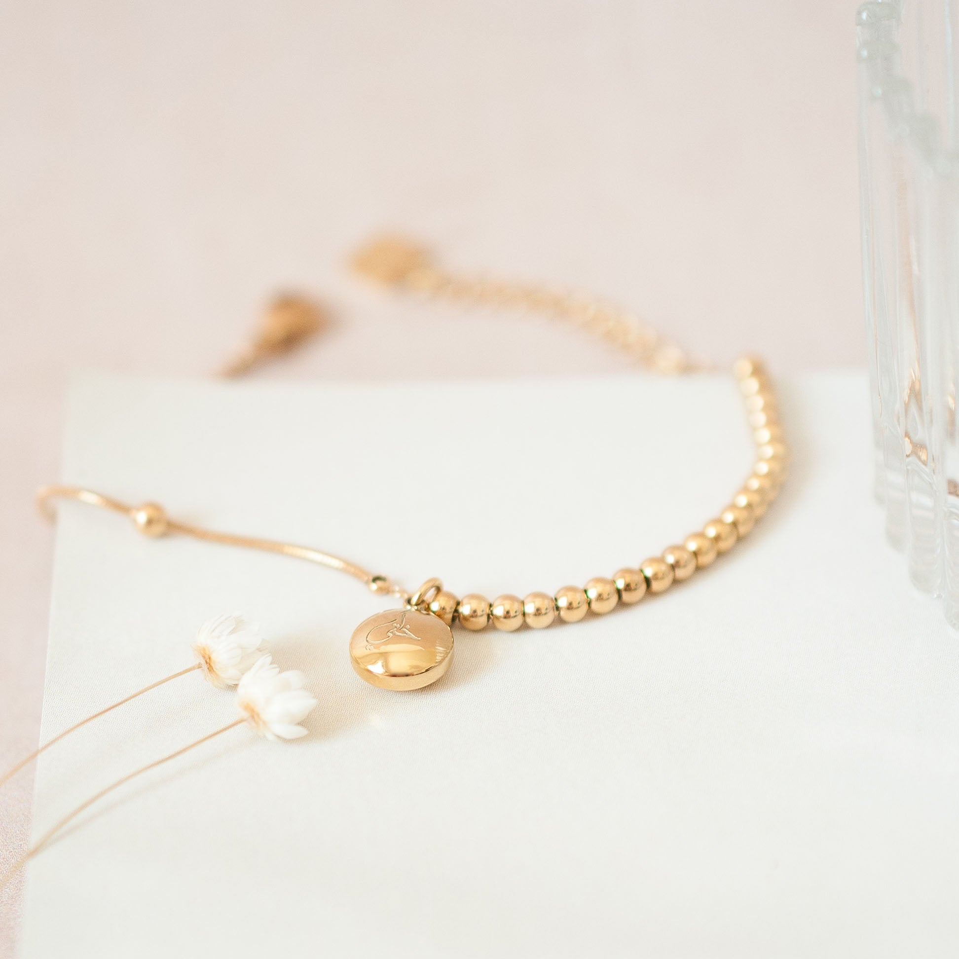 Close up of bead islamic bracelet in gold with 'my sister' engraved