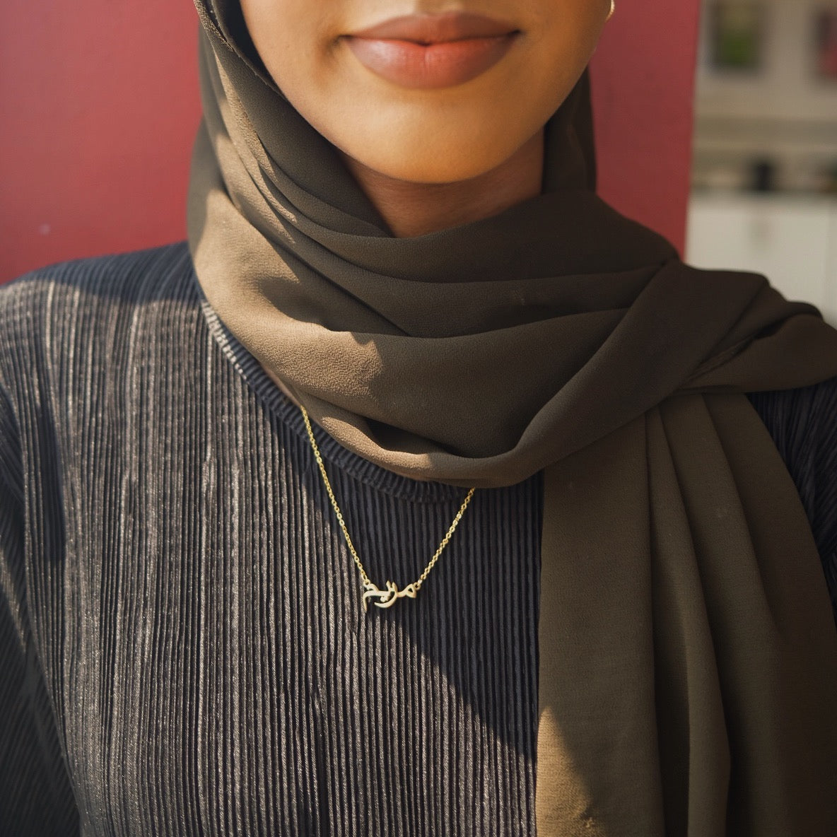 model wearing personalised Arabic name necklace in gold