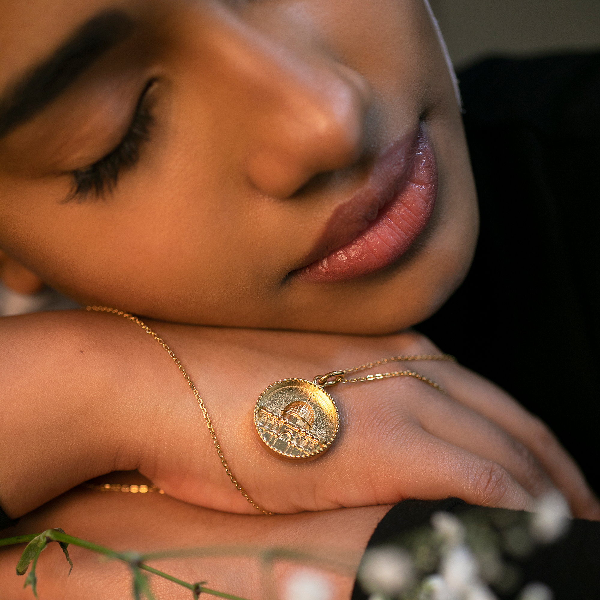 model holding gold dome of the rock necklace