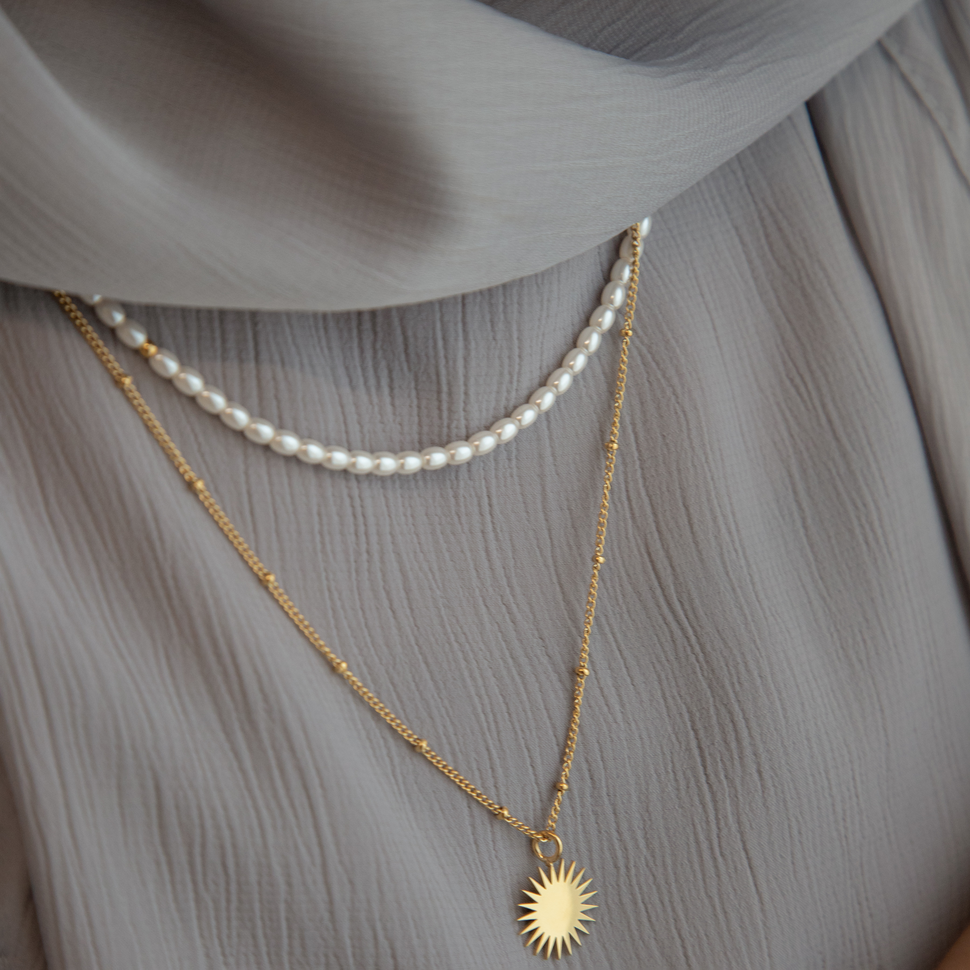 model wearing layering necklaces including the Tasbih pearl necklace