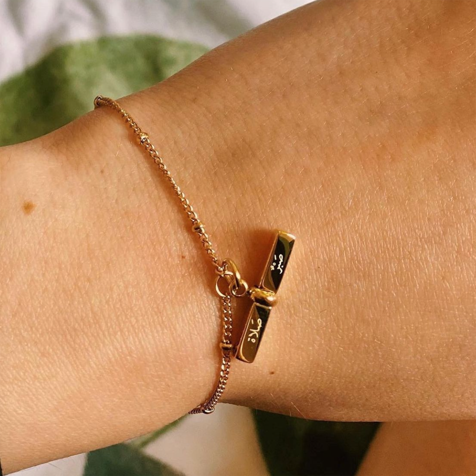 Model wearing 'patience & prayer' Arabic gold bracelet
