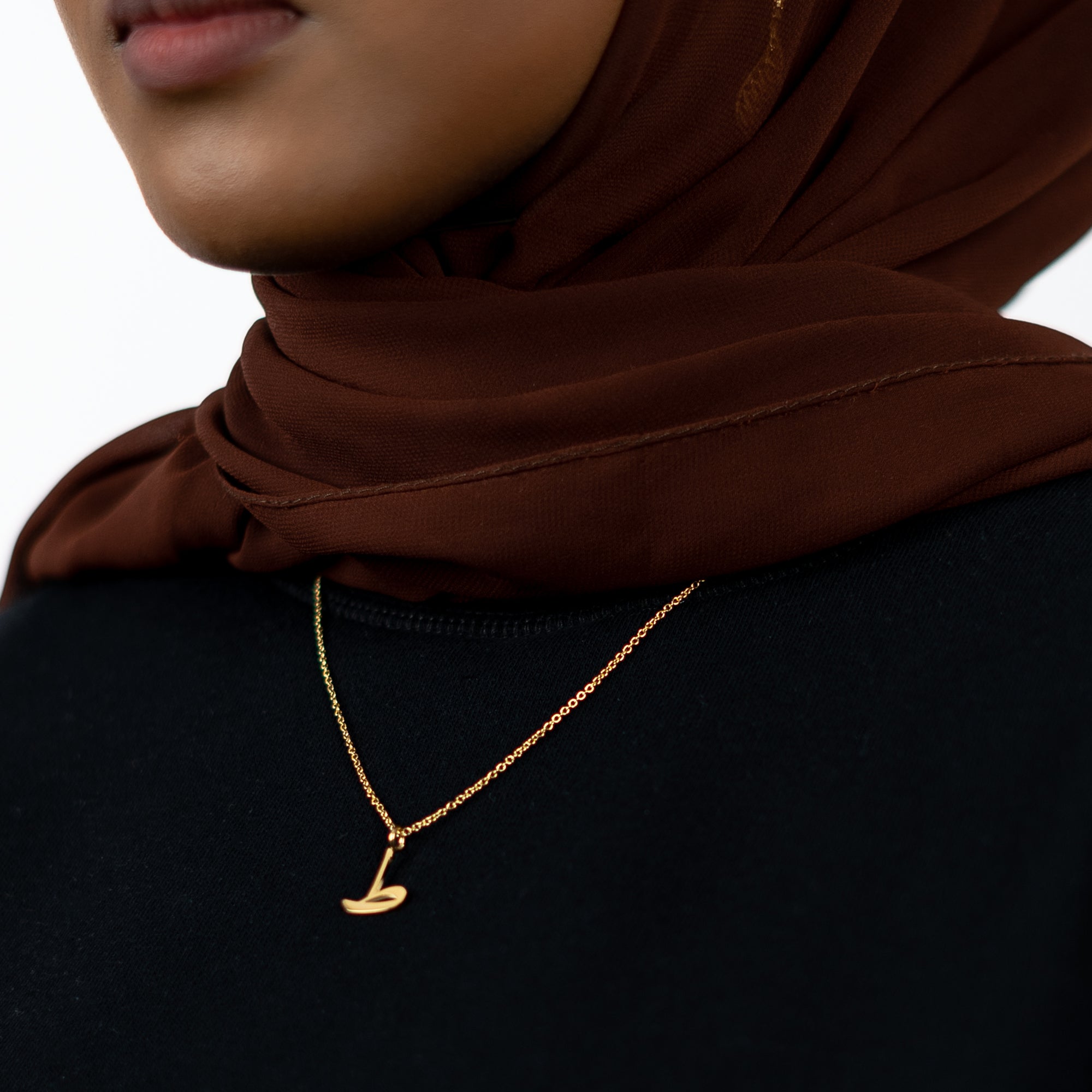 model wearing 18K gold plated Arabic letter necklace