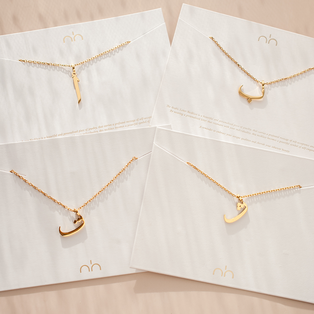 Arabic Letter Necklace Displayed Showing 5 Gold Letter Variations For The Necklace 
