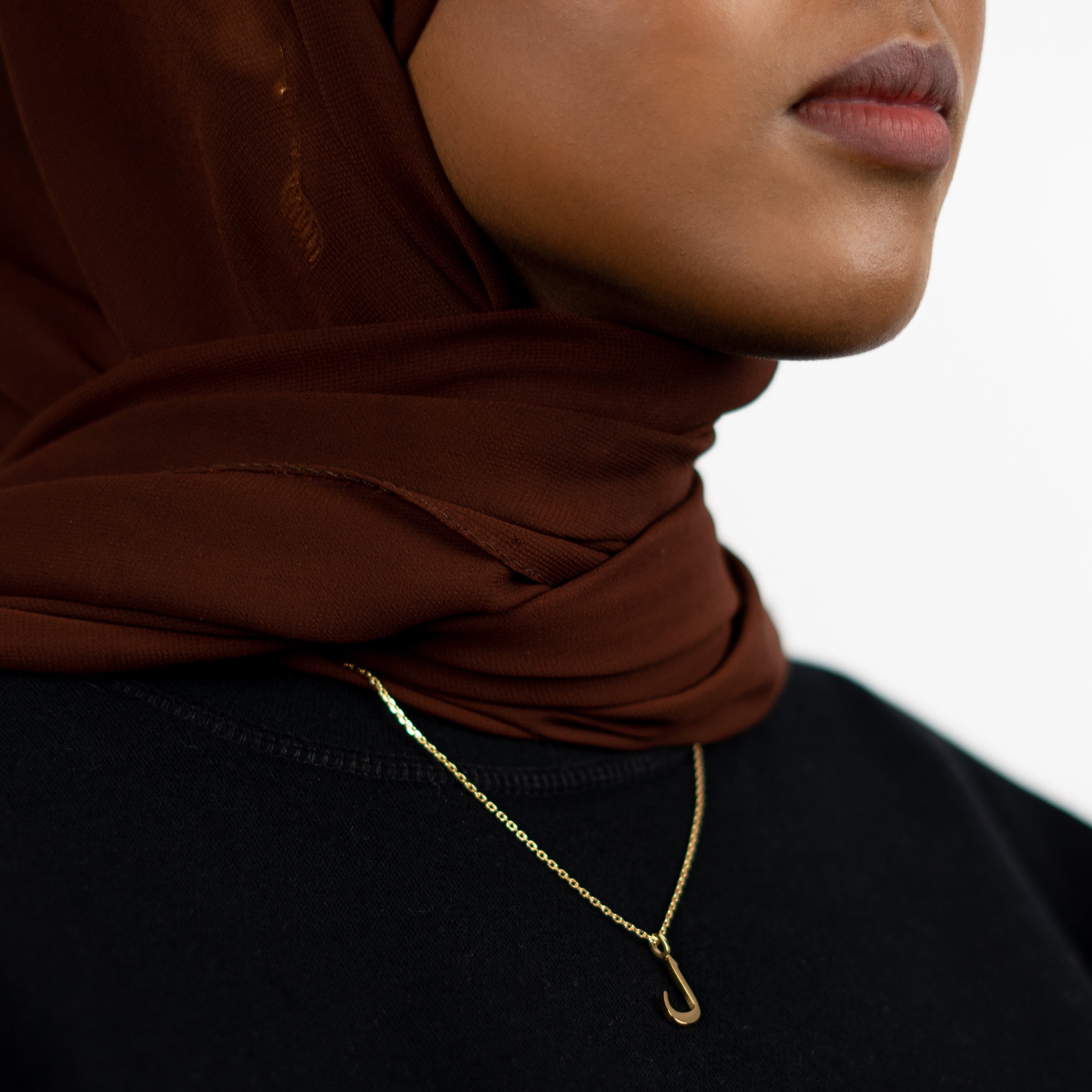 model wearing 18K gold plated Arabic letter necklace
