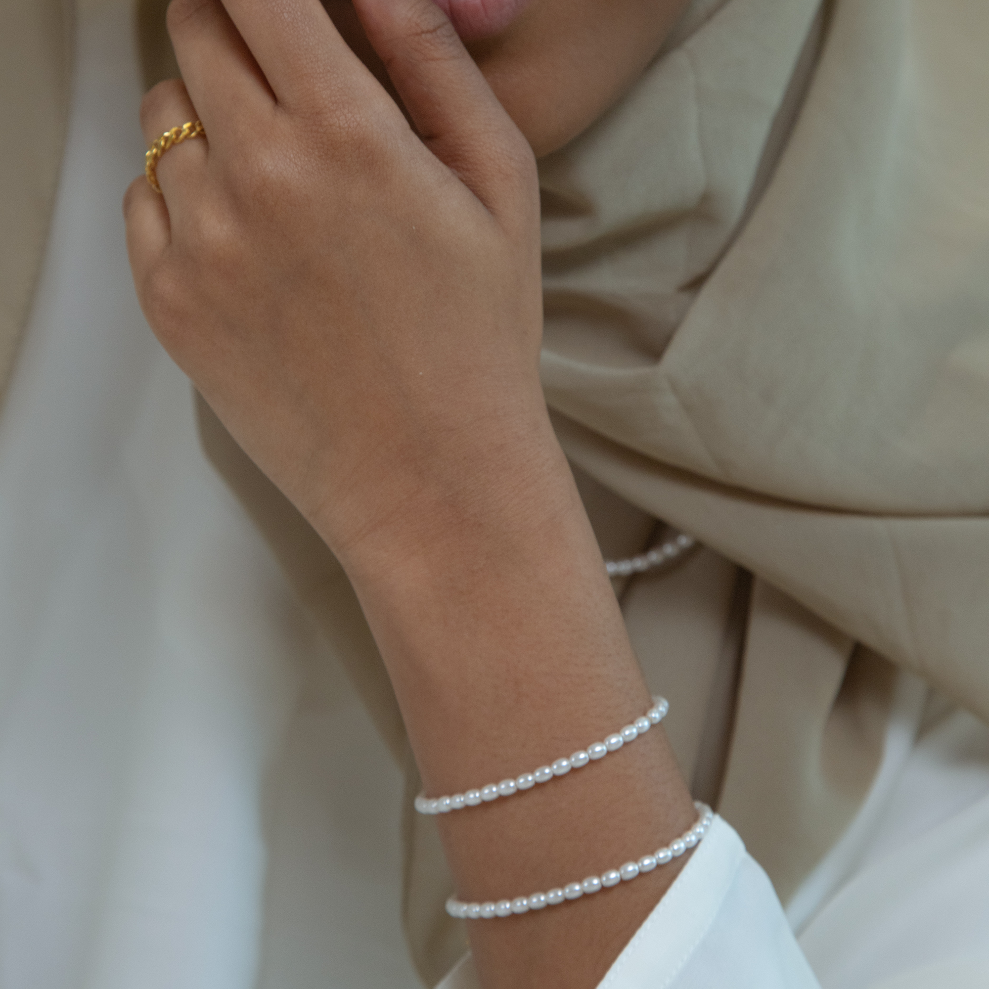 Model wearing a pair of pearl Arabic bracelets