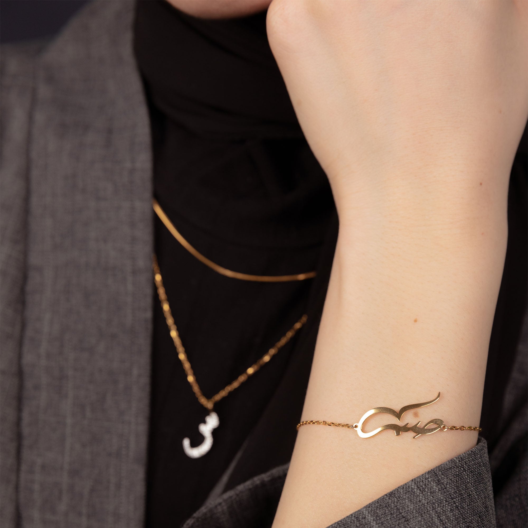 Model wearing islamic bracelet in gold with patience symbol